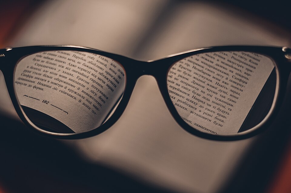 開いた本の上に置かれた老眼鏡