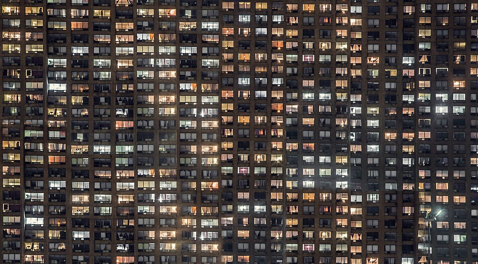夜、明かりのついた集合住宅の窓