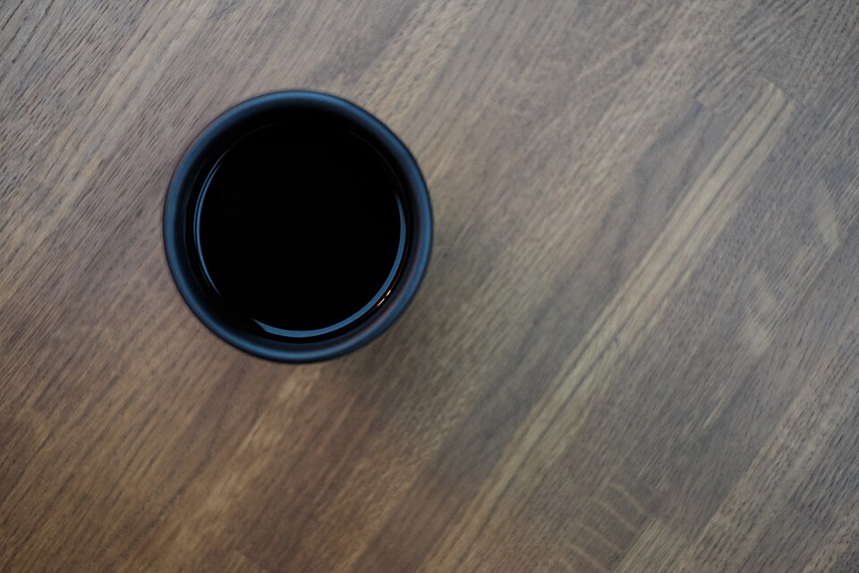 木のテーブルに置かれたコーヒーのマグカップ