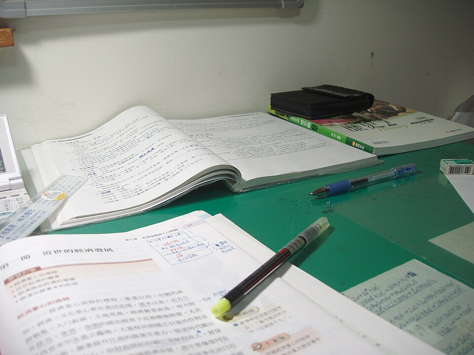 机の上に開いた教科書とペン
