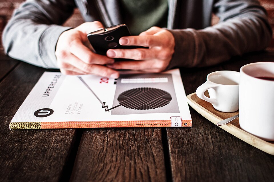テーブルに置かれたスマートフォンとコーヒー